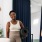 a person holding a yoga mat standing next to a person sitting on a chair